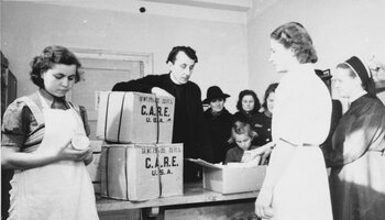 Verteilung von Care-Paketen. In der Mitte Rektor Georg Koch, 1947. | © (Fotograf unbekannt, Archiv des DiCV München und Freising e.V., Fotosammlung)