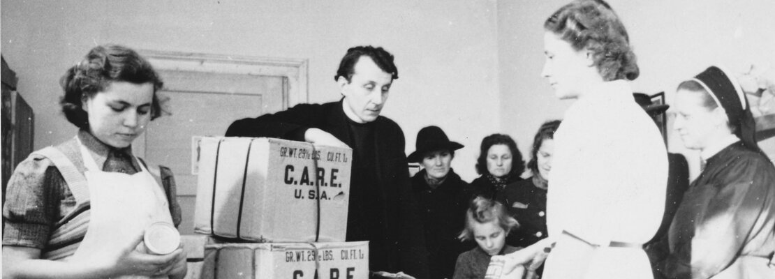 Verteilung von Care-Paketen. In der Mitte Rektor Georg Koch, 1947. | © (Fotograf unbekannt, Archiv des DiCV München und Freising e.V., Fotosammlung)