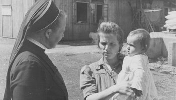 Im Flüchtlingslager Allach II: Eine Vertriebene aus dem Sudetenland spricht mit einer Caritasschwester, ca. 1947. | © (Fotograf unbekannt, Archiv des DiCV München und Freising e.V., Fotosammlung)