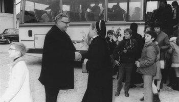 Franz Sales Müller begrüßt Schwester Agnes beim Reisebus beim Einzug in das neue Haus am 27. Februar 1972. | © (Fotograf unbekannt, Archiv des DiCV der Erzdiözese München und Freising e. V., Fotosammlung)
