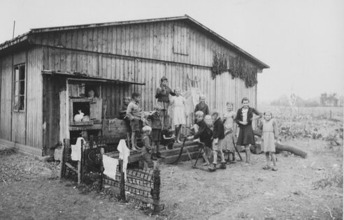 Kinder vor einer Baracke im Lager Allach b. München, ca. 1947. | © (Fotograf unbekannt, Archiv des DiCV München und Freising e. V., Fotosammlung)