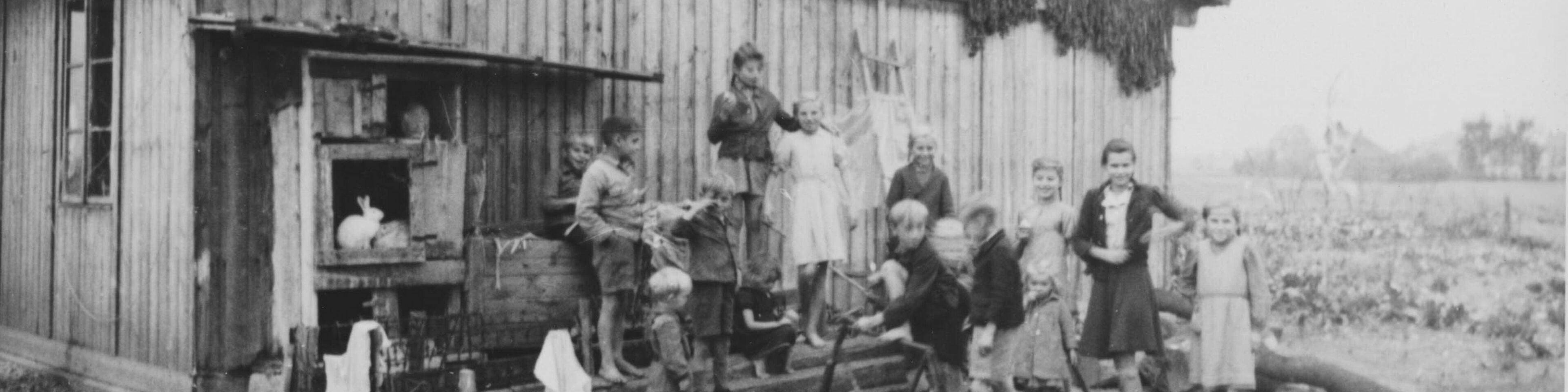 Kinder vor einer Baracke im Lager Allach b. München, ca. 1947. | © (Fotograf unbekannt, Archiv des DiCV München und Freising e. V., Fotosammlung)