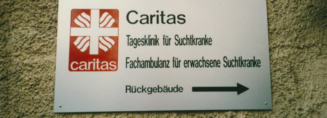 Schild der Caritas-Tagesklinik für Suchtkranke und Fachambulanz für erwachsene Suchtkranke, ca. 1990.  | © (Fotograf unbekannt, Archiv des DiCV München und Freising e. V., Fotosammlung)